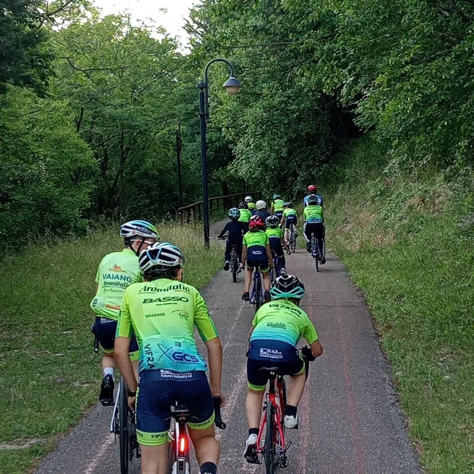 Giovani ciclisti di Vaiano Bike pedalano insieme lungo un percorso nel verde